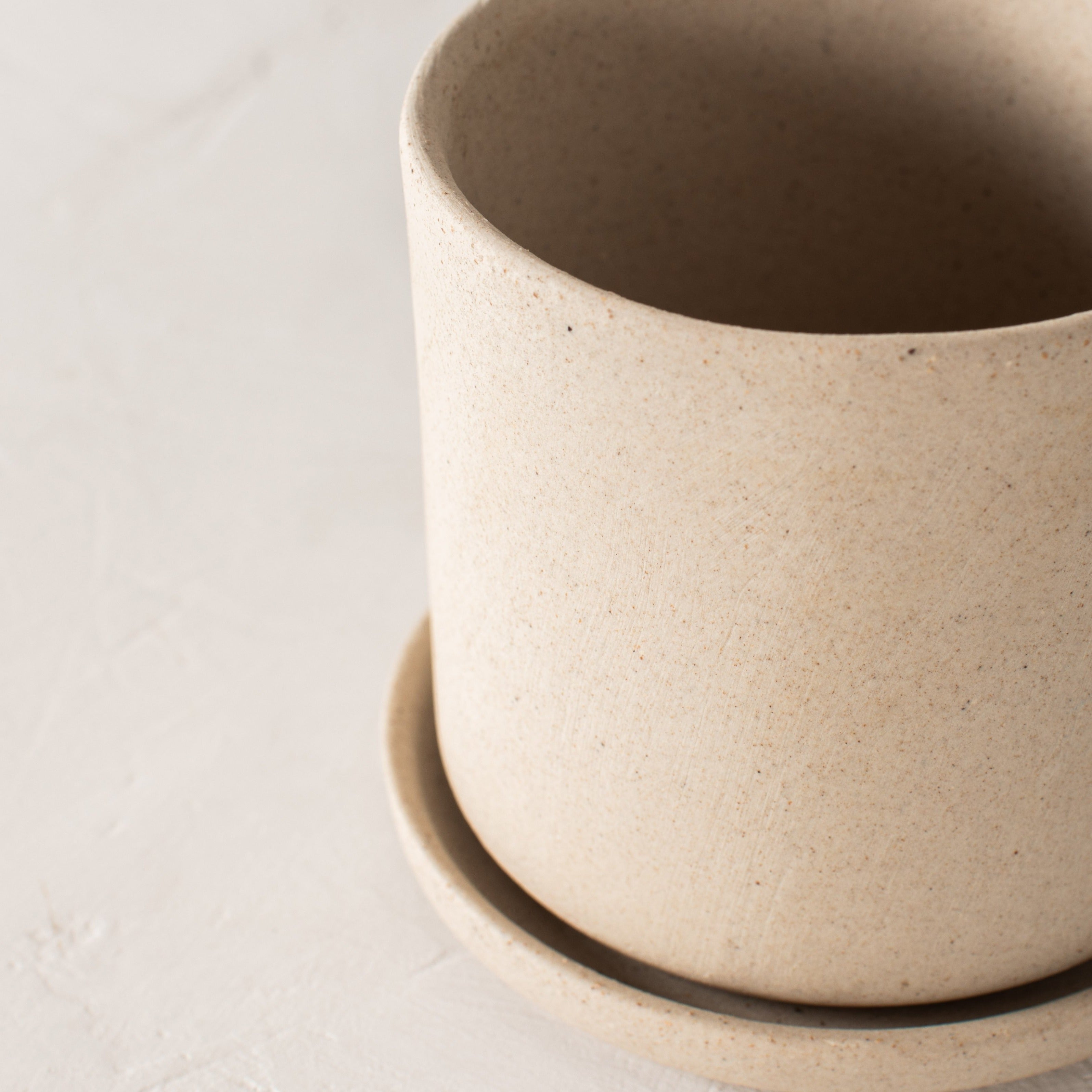 Sand stoneware ceramic planter close up, with drainage dish. Handmade ceramic planters designed and sold by Convivial Production, Kansas City Ceramics.