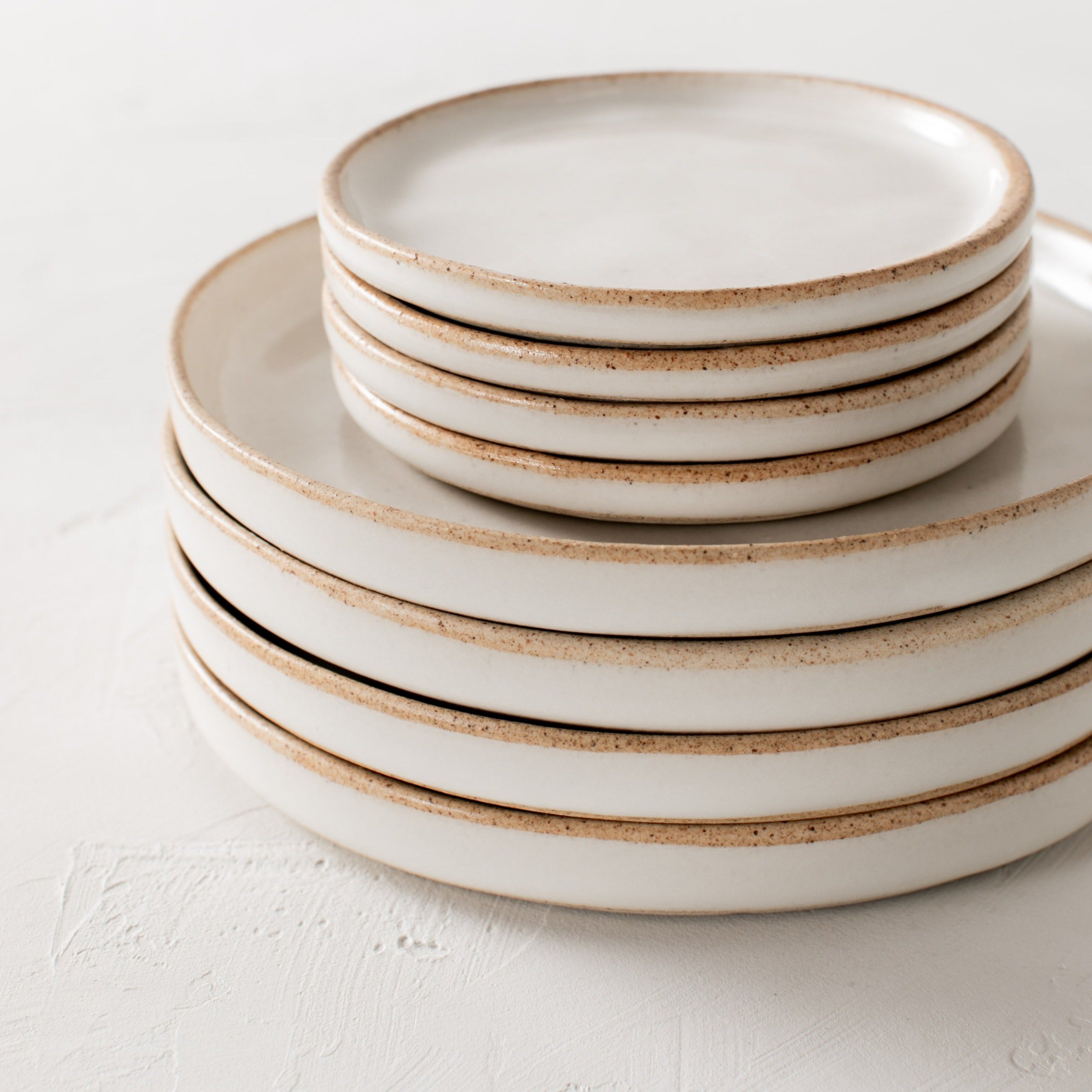 Stack of minimal raised edged dishes with exposed stoneware rim. Dishes designed and sold by Convivial Production, Kansas City ceramics.